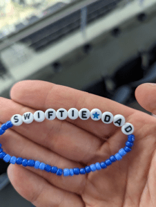 Friendship bracelet that says "Swiftie Dad" in its beads.